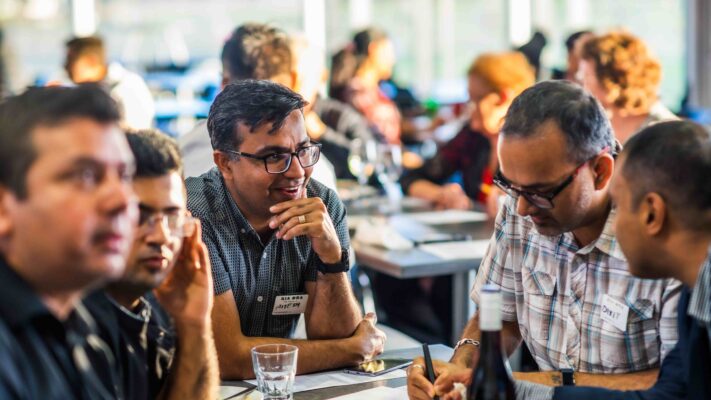 Green Business HQ event showing group of men sitting at table actively in discussion